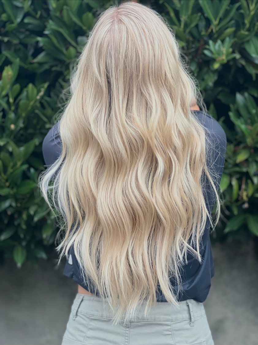 Long, dimensional lived-in blonde hair styled in soft waves, photographed outdoors